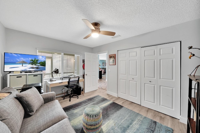 office area featuring ceiling fan, a textured ceiling, and light hardwood / wood-style flooring