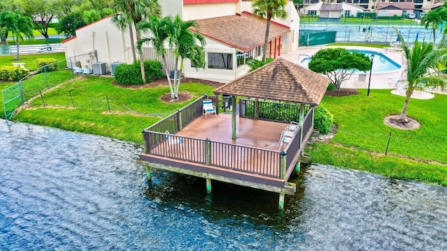 view of dock featuring a gazebo, central AC unit, a lawn, and a swimming pool side deck with water view