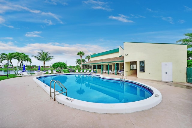 view of swimming pool featuring a water view and a patio