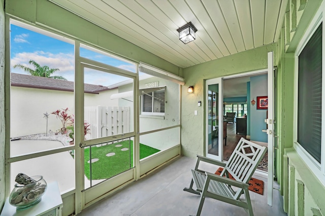 sunroom / solarium featuring a healthy amount of sunlight and wooden ceiling