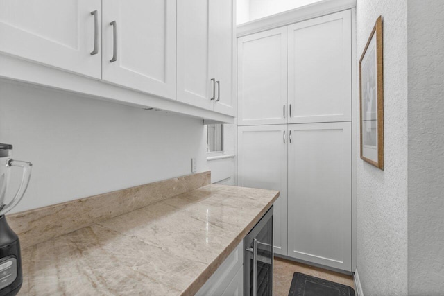 kitchen featuring wine cooler and white cabinets