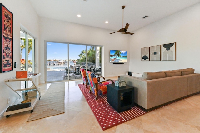 living room with ceiling fan, plenty of natural light, and light tile patterned floors