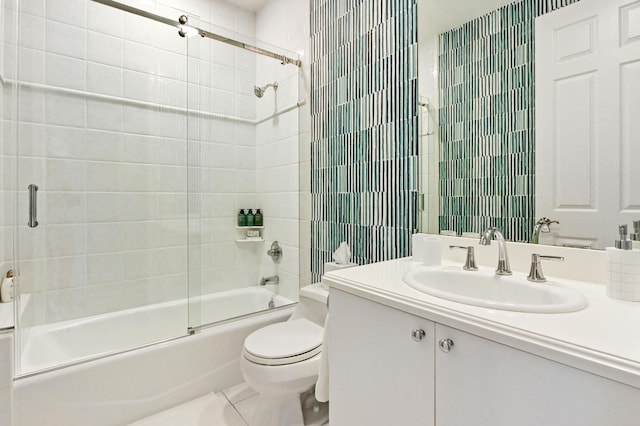 full bathroom featuring combined bath / shower with glass door, tile patterned floors, vanity, and toilet