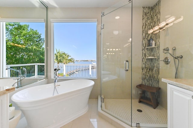 bathroom featuring tile patterned floors, plus walk in shower, plenty of natural light, and a water view