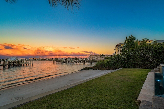 dock area featuring a lawn and a water view