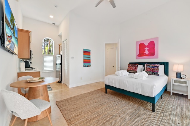 bedroom featuring light tile patterned floors, a towering ceiling, a closet, and ceiling fan