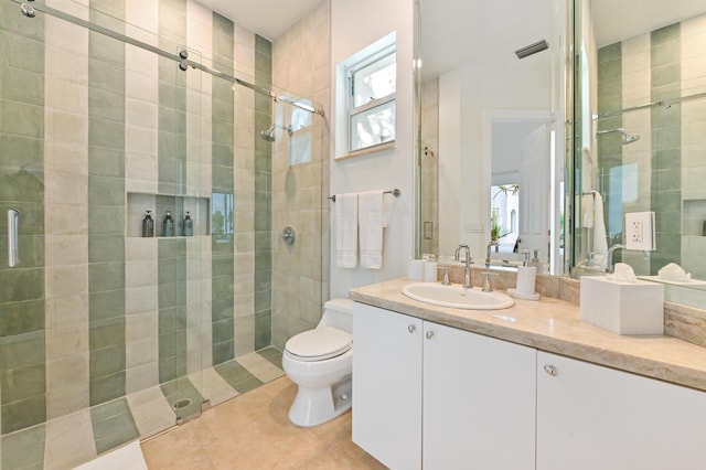 bathroom with tile patterned flooring, a shower with door, vanity, and toilet