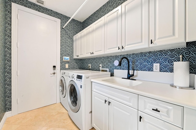 washroom with washer and dryer, sink, light tile patterned flooring, and cabinets