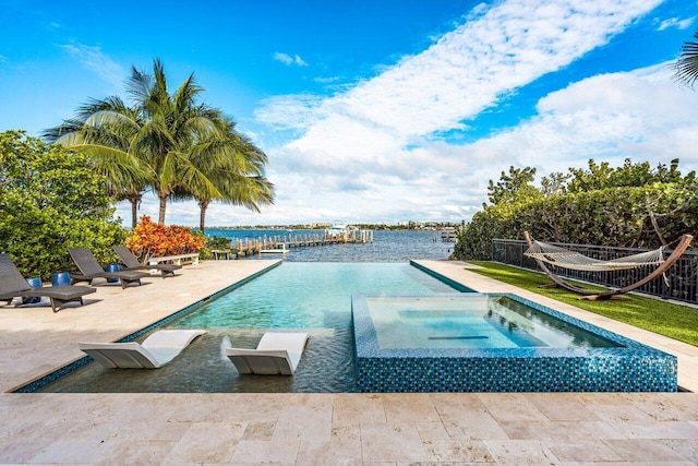 view of pool featuring an in ground hot tub, a patio, and a water view