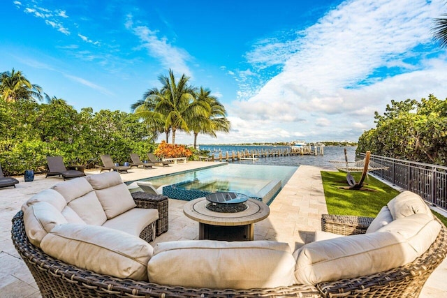 view of swimming pool featuring a water view, a patio, and an outdoor fire pit