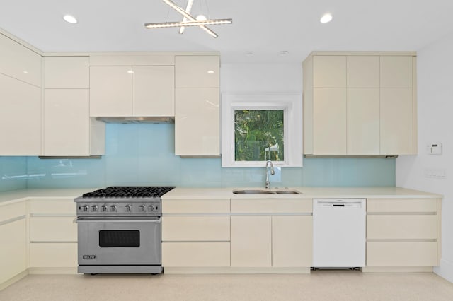 kitchen featuring dishwasher, sink, tasteful backsplash, a notable chandelier, and premium range