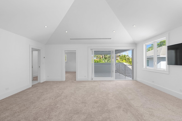 unfurnished living room featuring light colored carpet and lofted ceiling