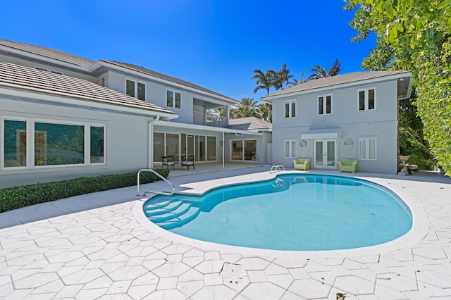 view of swimming pool featuring a patio and french doors