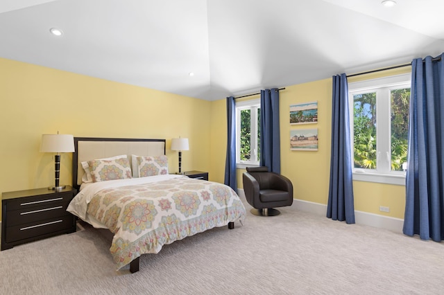 carpeted bedroom featuring multiple windows and vaulted ceiling