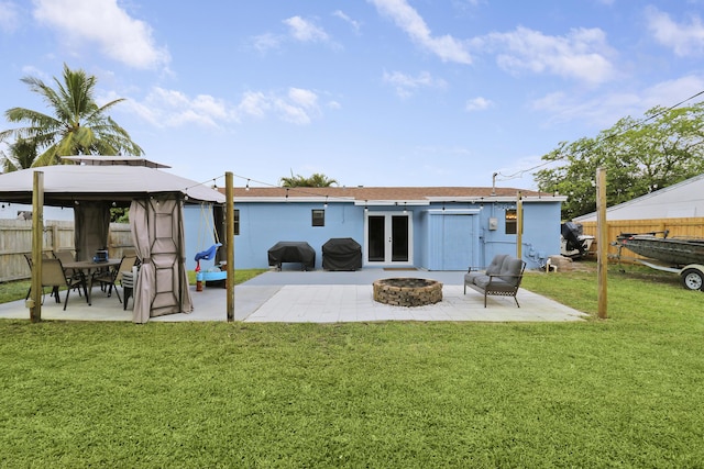 rear view of property with a gazebo, a patio area, french doors, and a lawn