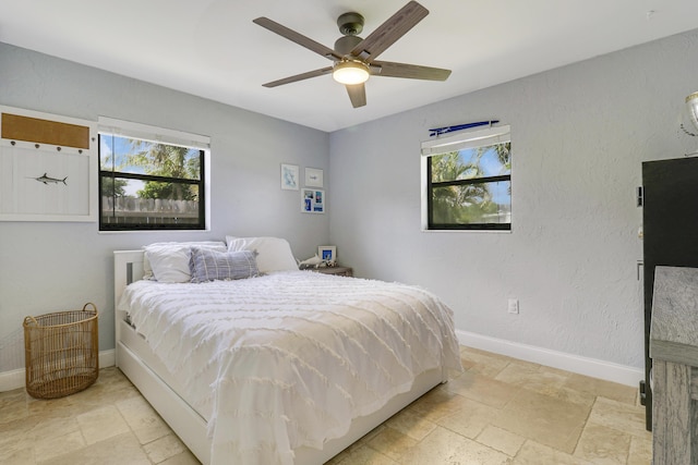 bedroom with ceiling fan and multiple windows