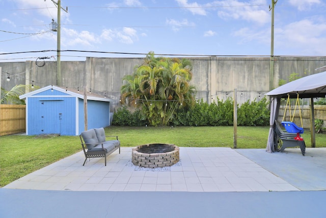 view of patio / terrace featuring a storage shed and an outdoor fire pit