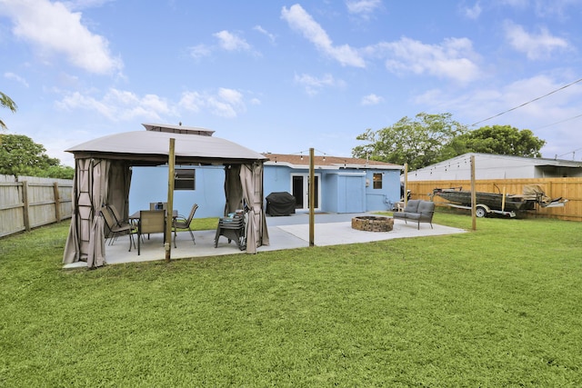 rear view of house featuring a gazebo, a yard, an outdoor fire pit, and a patio