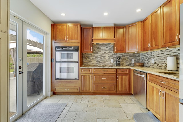 kitchen featuring decorative backsplash, light stone counters, and appliances with stainless steel finishes