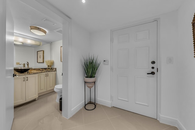 foyer entrance featuring light tile patterned floors and sink