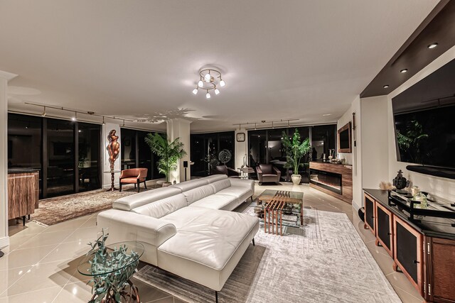 living room with light tile patterned floors, a notable chandelier, and expansive windows