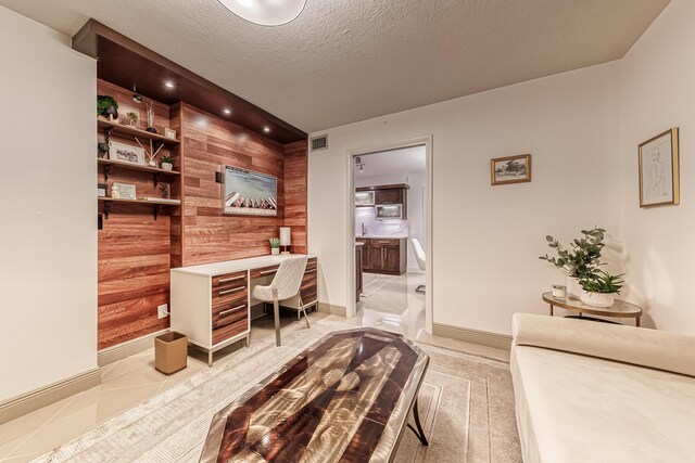 office featuring a textured ceiling and wood walls