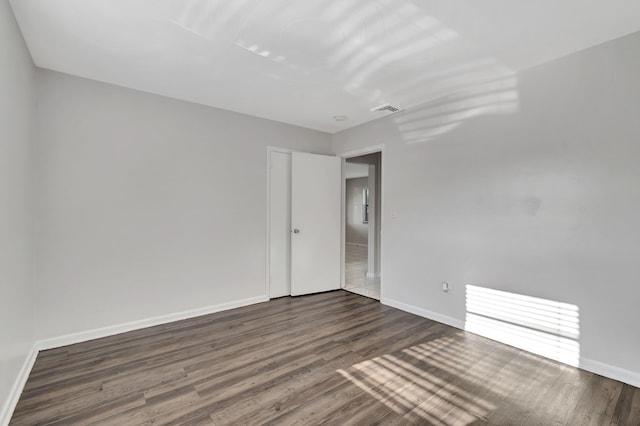 empty room with dark hardwood / wood-style floors