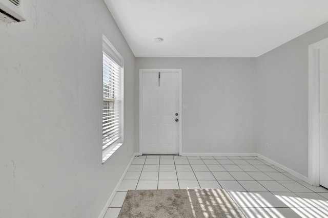 tiled spare room featuring a wall mounted air conditioner