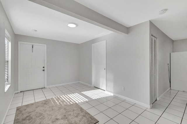 interior space featuring beamed ceiling and light tile patterned floors