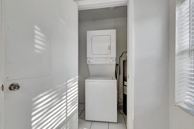 washroom with light tile patterned floors and stacked washer and clothes dryer