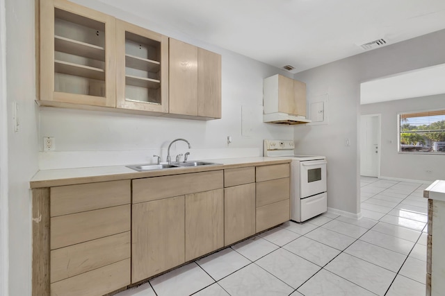 kitchen with light tile patterned flooring, light brown cabinetry, electric range, and sink