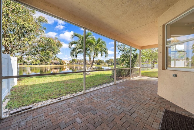 unfurnished sunroom featuring a water view