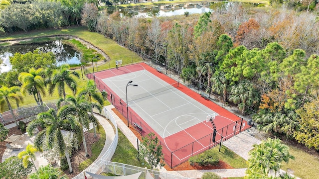 view of sport court featuring tennis court and a water view