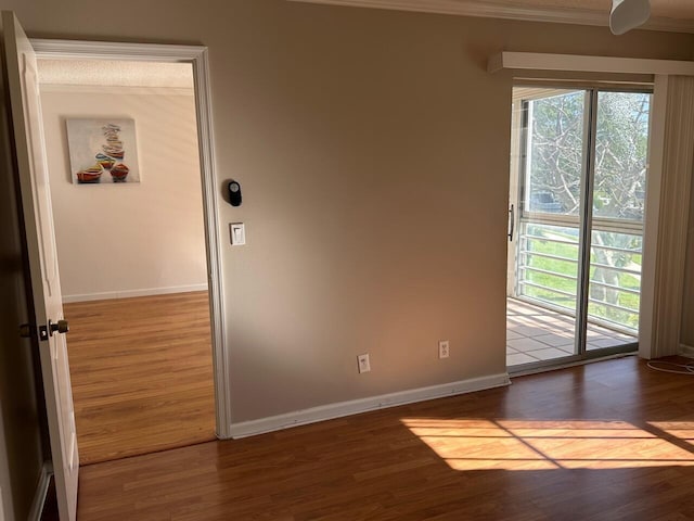 unfurnished room with wood-type flooring and crown molding