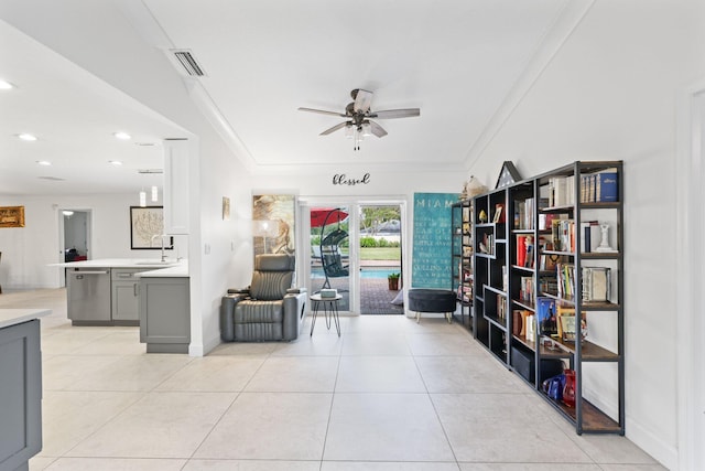 sitting room featuring ceiling fan, sink, light tile patterned floors, and ornamental molding