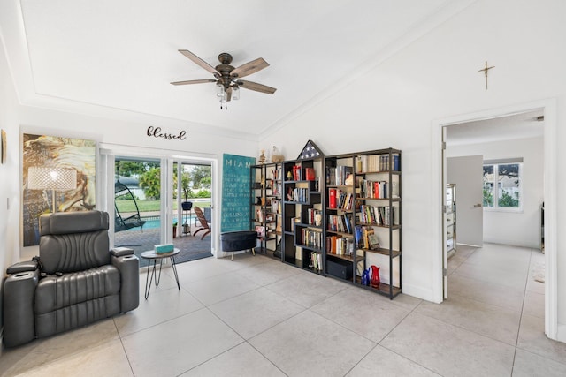 living area with ceiling fan, ornamental molding, and light tile patterned flooring