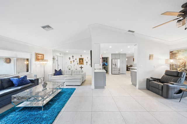 living room with ceiling fan, light tile patterned floors, vaulted ceiling, and ornamental molding