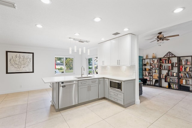 kitchen featuring stainless steel appliances, gray cabinetry, decorative light fixtures, ornamental molding, and sink