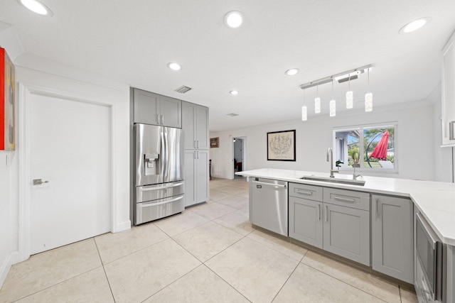 kitchen with light tile patterned floors, appliances with stainless steel finishes, gray cabinetry, hanging light fixtures, and sink