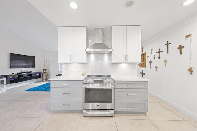 kitchen featuring white cabinets, wall chimney exhaust hood, stainless steel range with electric cooktop, gray cabinets, and ornamental molding