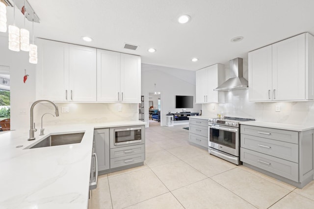 kitchen with sink, white cabinets, appliances with stainless steel finishes, and wall chimney exhaust hood