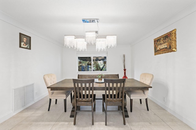 dining room featuring light tile patterned floors, a chandelier, and ornamental molding