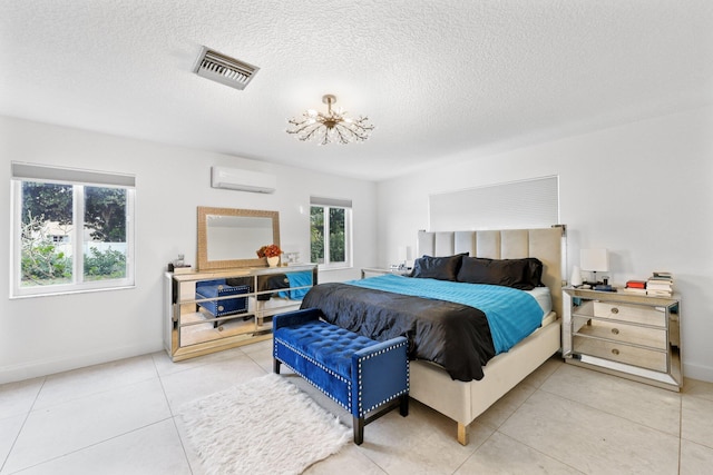 bedroom featuring an AC wall unit, a textured ceiling, and tile patterned flooring