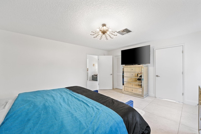 tiled bedroom with a chandelier and a textured ceiling