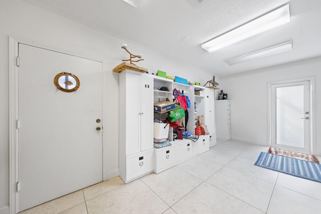 mudroom featuring a textured ceiling and light tile patterned floors