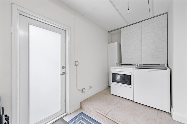 laundry area with washer and dryer and light tile patterned flooring