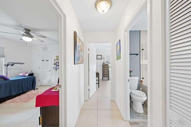 hall featuring a textured ceiling and light tile patterned flooring