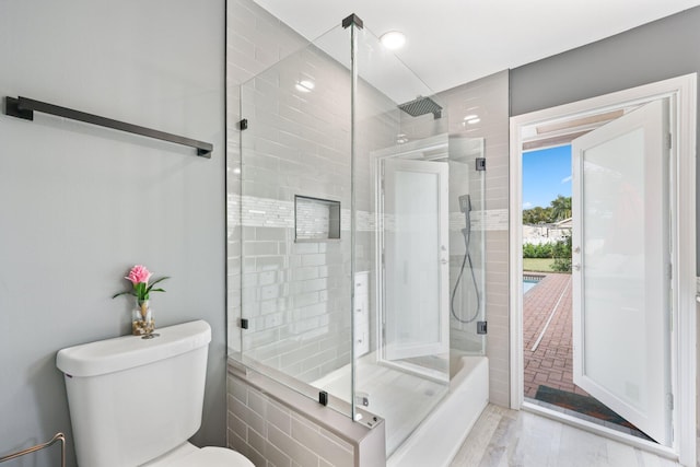 bathroom with toilet, wood-type flooring, and a shower with door