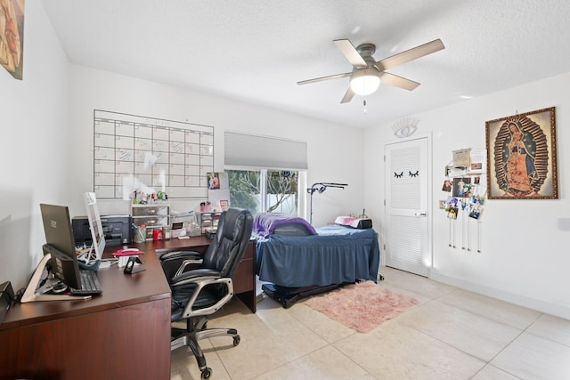 tiled bedroom with ceiling fan and a textured ceiling