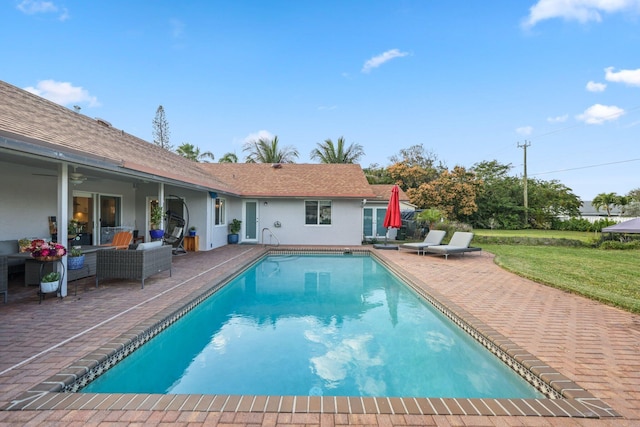 view of swimming pool featuring a patio area, outdoor lounge area, and a lawn